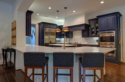 Corner of Kitchen Countertop with Three Blue chairs in Front of It and Blue Cabinets