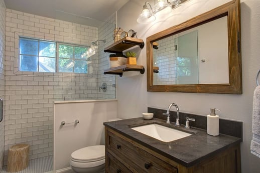 Dallas bathroom with dark wood mirror, vanity, and floating shelves.