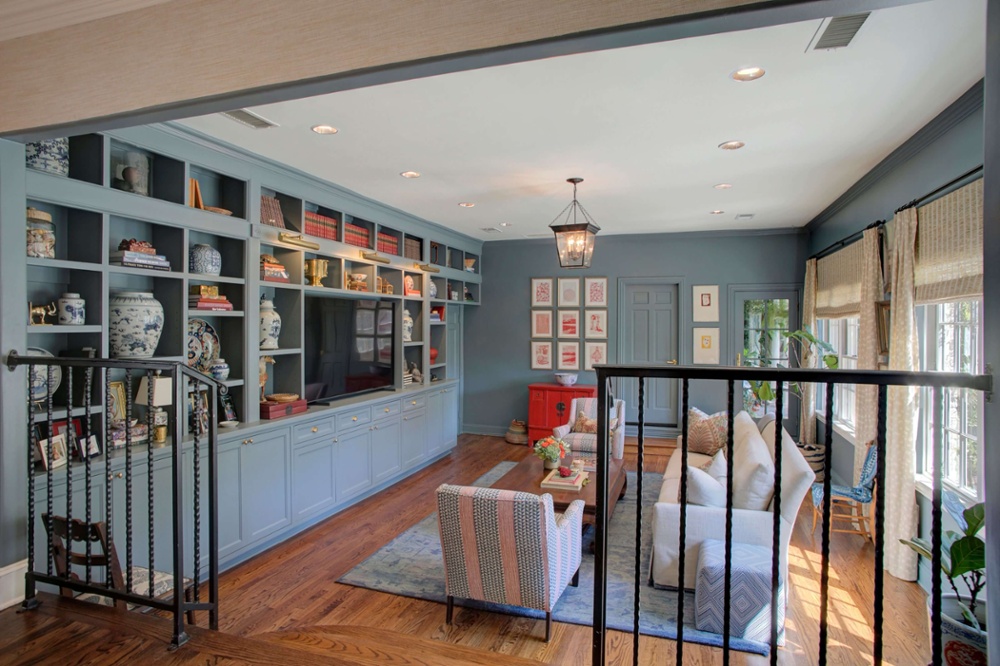 Step-down living room with wood floors and built-in bookcase.