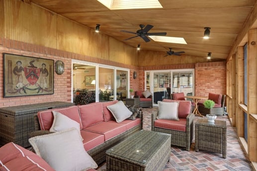 Screened-in porch with wood beam ceiling. 