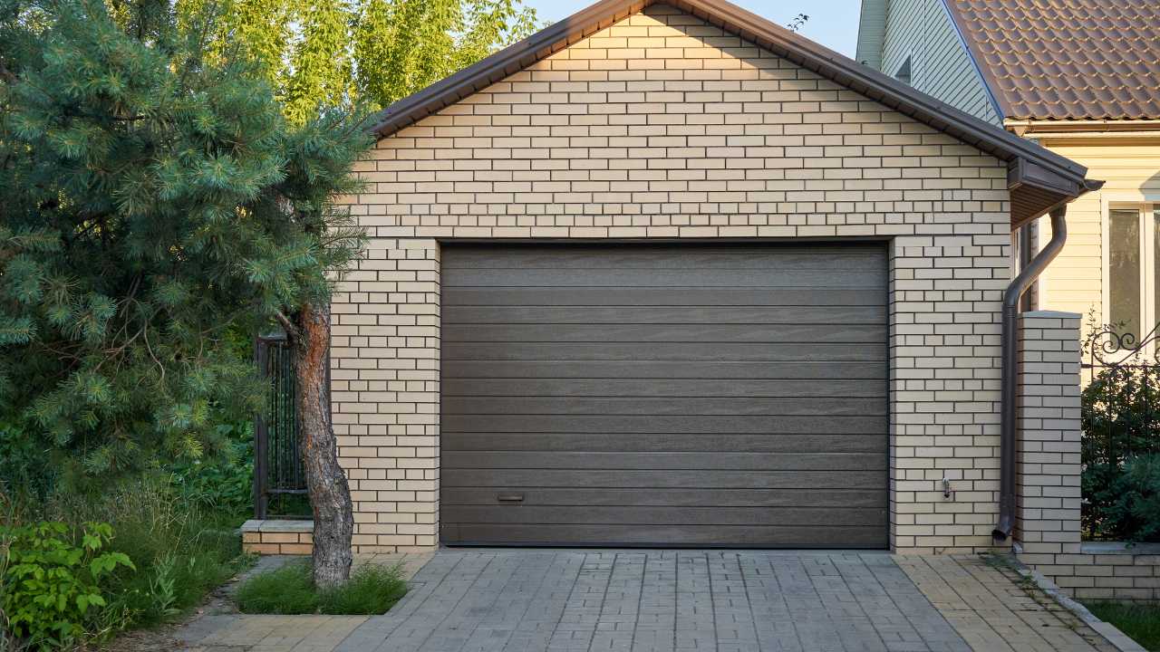 Dark Brown Garage Door Surrounded by Brick