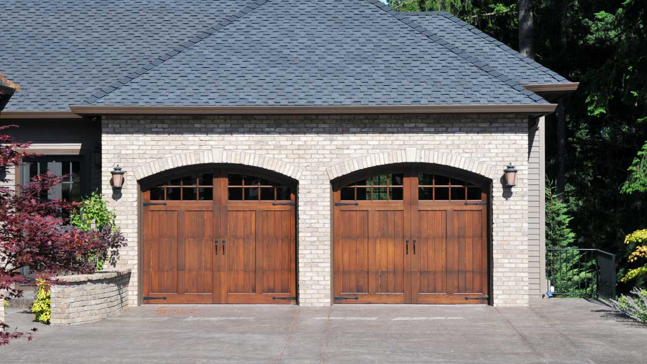Two Wooded Garage Doors Attached to Stylized Home