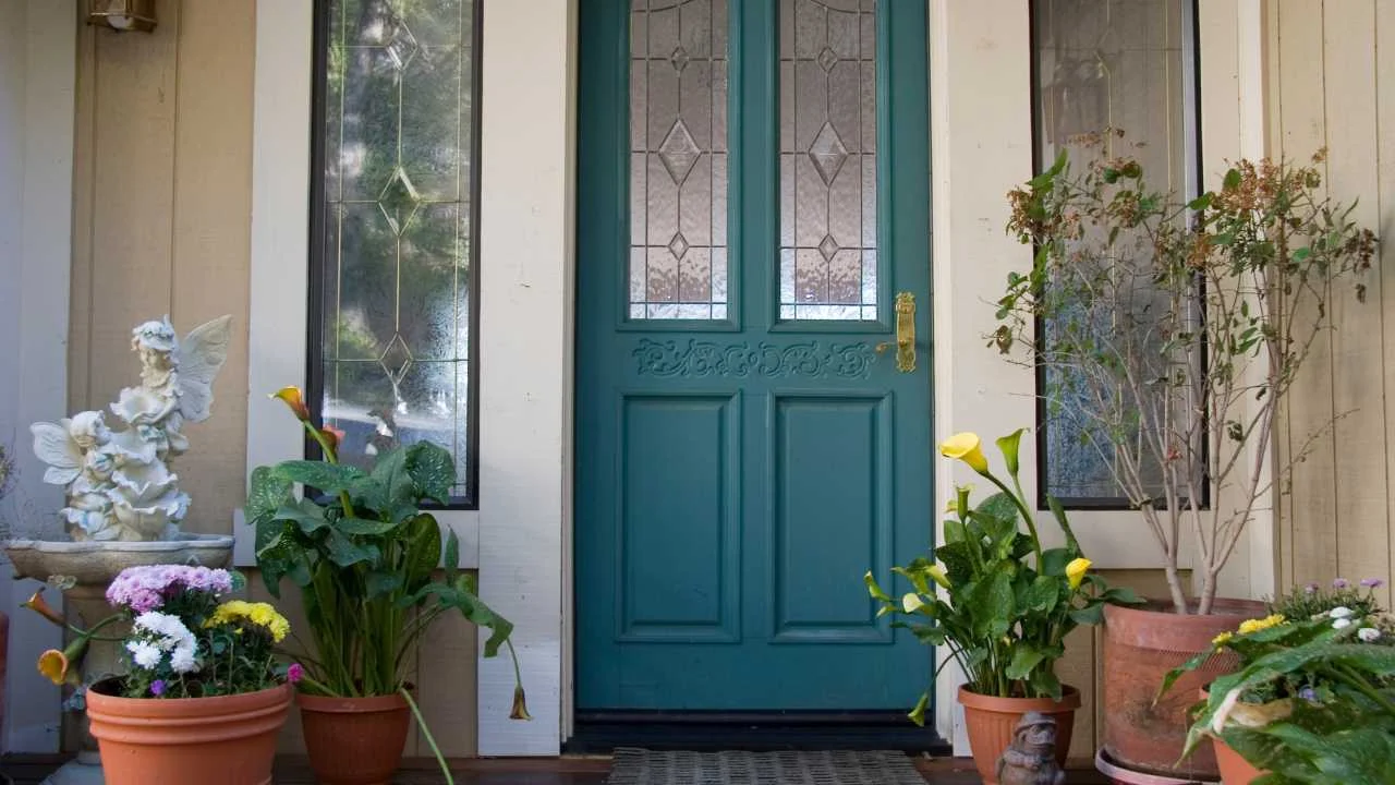 Teal Wooded Door Leading to Home with Plants